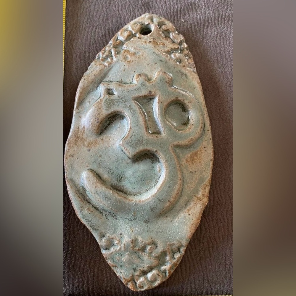 Hand made wall hanging ceramic Om sign.